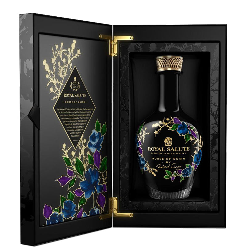 Royal Salute House Of Quinn whisky in een zwarte karaf met bloemen in een geopende geschenkdoos.